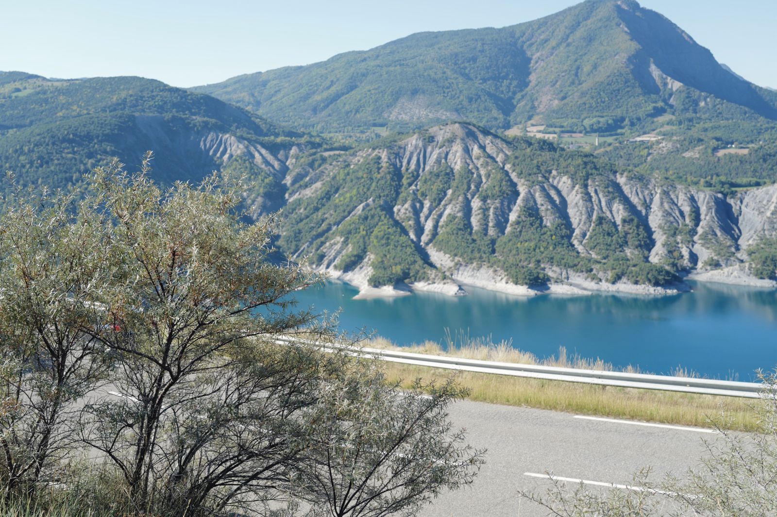 A reservoir below eroded grey cliffs
