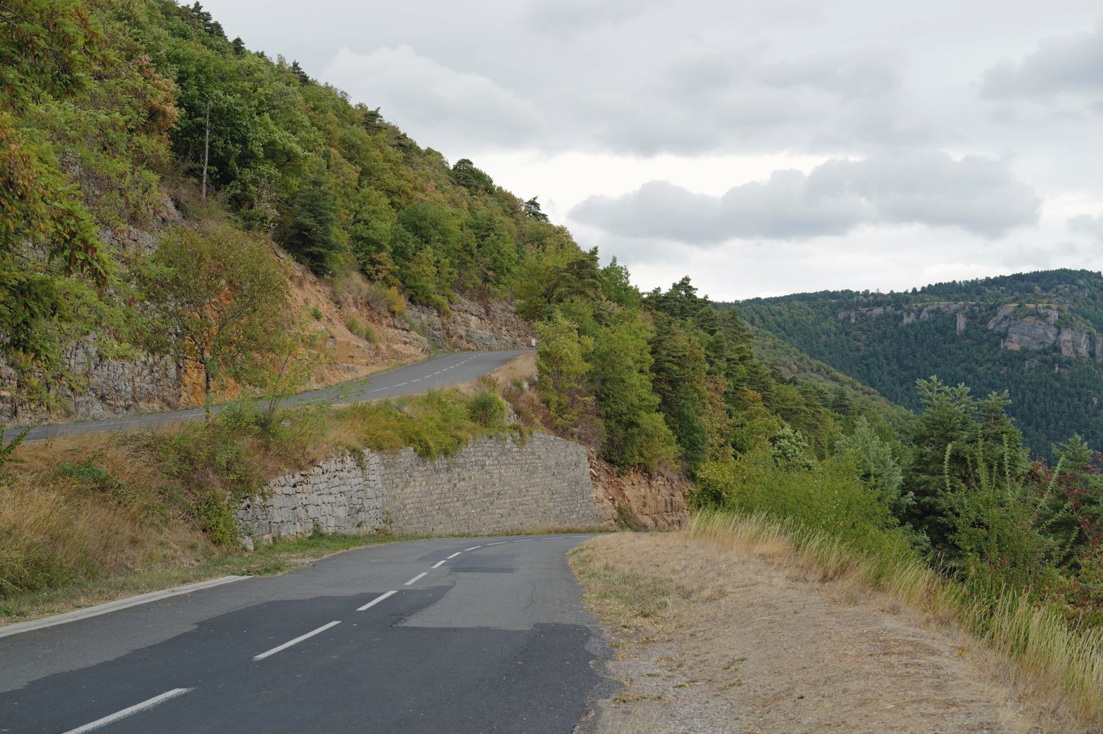 A winding road beside a stone wall