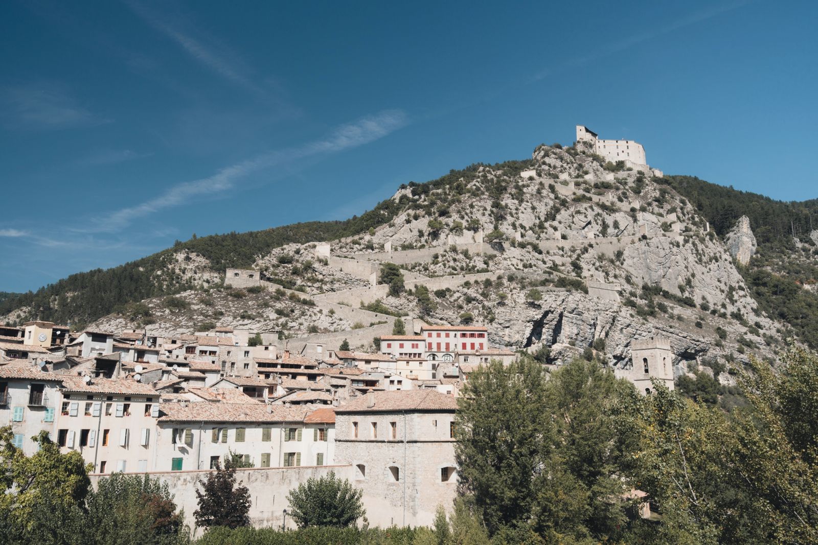 A stone village under a hilltop fort